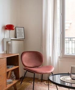 a living room with a chair and a glass table at Nouveau T2 à 7 min de Saint-Lazare in Asnières-sur-Seine
