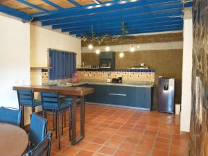 a large kitchen with a table and a refrigerator at LONGO VI in San Antonio de las Alzanas