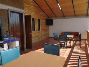 a room with a table and chairs and a kitchen at LONGO VI in San Antonio de las Alzanas