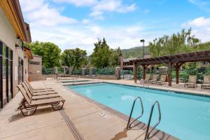 a swimming pool with chaise lounges next to a building at Park Avenue by All Seasons Resort Lodging in Park City
