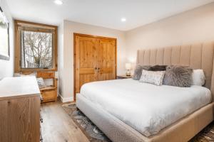 a bedroom with a large white bed and a window at Payday by All Seasons Resort Lodging in Park City