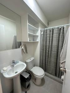 a white bathroom with a toilet and a sink at Apartamento de estreno San Bartolo vista Piscina Playa in San Bartolo