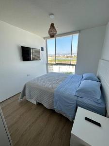 sypialnia z łóżkiem i dużym oknem w obiekcie Apartamento de estreno San Bartolo vista Piscina Playa w mieście San Bartolo