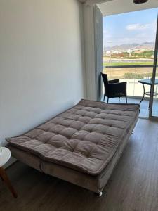 duże łóżko w pokoju z dużym oknem w obiekcie Apartamento de estreno San Bartolo vista Piscina Playa w mieście San Bartolo