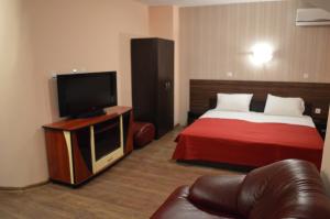 a hotel room with a bed and a flat screen tv at Bon Bon Hotel in Sofia