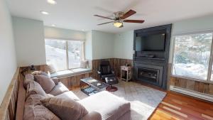 ein Wohnzimmer mit einem Sofa, einem TV und einem Kamin in der Unterkunft Hidden Creek by All Seasons Resort Lodging in Park City