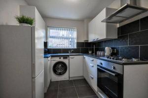 a kitchen with a washing machine and a dishwasher at Sleeps 7 guests, great location in Liverpool