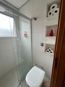 a bathroom with a toilet and a glass shower at 2 Min da Praia! / 2 Quartos / Vaga de Garagem in Santos