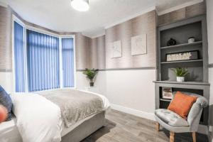 a bedroom with a bed and a chair and a window at Sleeps 7 guests, great location in Liverpool