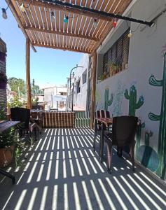 eine Terrasse mit Stühlen, Tischen und einem Kaktus-Wandbild in der Unterkunft Pequeña Estación B&B in Mendoza