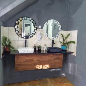 a bathroom with two mirrors and a sink at Pequeña Estación B&B in Mendoza