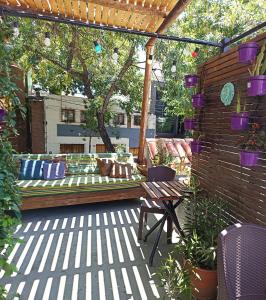 un patio con un banco bajo una pérgola en Pequeña Estación B&B en Mendoza