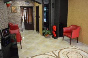 a hallway with two red chairs and a plant at Bon Bon Hotel in Sofia