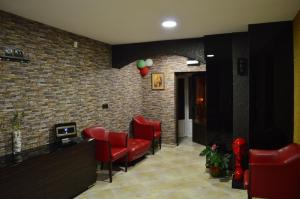 a waiting room with red chairs and a brick wall at Bon Bon Hotel in Sofia