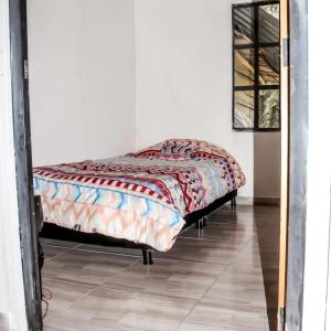 una cama sentada en una habitación junto a un espejo en Villas de Sanjuan, en Suesca