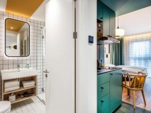 a bathroom with green cabinets and a sink at Aparthotel Adagio access Hamburg in Hamburg