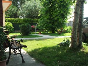 una panchina da parco seduta sull'erba accanto a un albero di B&B Casa Vally a Dolo