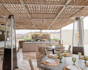 a patio with tables and chairs and a kitchen at Hotel Andana Winery & Spa in Valle de Guadalupe