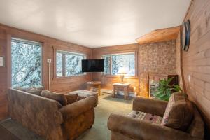 a living room with two couches and a flat screen tv at Darwin's in Girdwood