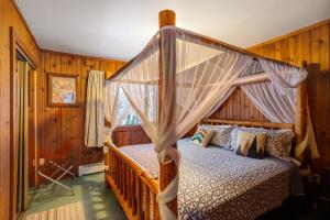 a bedroom with a bed with a canopy at Darwin's in Girdwood