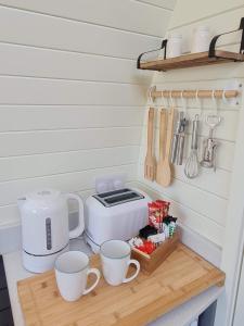 a kitchen counter with cups and a toaster and utensils at Two Peas in a Pod in Holyhead