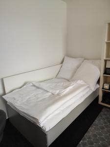 Una cama con sábanas blancas y almohadas. en Apartmán Rokytnička, en Rokytnice v Orlických horách