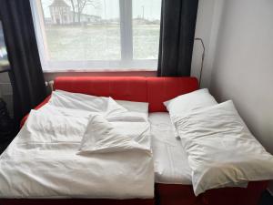 a bed with white sheets and pillows in front of a window at Apartmán Rokytnička in Rokytnice v Orlických Horách