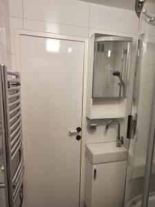 een witte badkamer met een wastafel en een spiegel bij Apartmán Rokytnička in Rokytnice v Orlických Horách