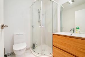 ein Bad mit einer Dusche, einem WC und einem Waschbecken in der Unterkunft Cozy Brand New Townhouse 3 in Auckland