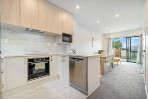 eine Küche mit weißen Geräten und einem großen Fenster in der Unterkunft Cozy Brand New Townhouse 3 in Auckland