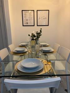 a glass dining table with plates and glasses on it at La Casita Real in Vigo