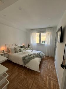 ein Schlafzimmer mit einem großen Bett und Holzboden in der Unterkunft La Casita Real in Vigo