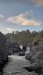 Valencia de dos cascadas en un río con rocas en Chakana en Villa Yacanto