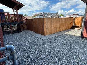 a wooden fence in a yard with a gate at Beautiful Suite In Cranbrook! in Cranbrook