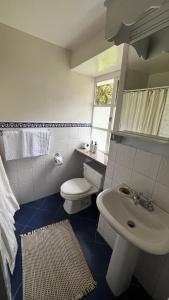 a bathroom with a white toilet and a sink at Hacienda Cusin in Otavalo