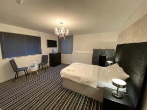 ein Hotelzimmer mit einem Bett, einem Schreibtisch und Stühlen in der Unterkunft STIFFORD CLAYS FARM HOTEL in North Stifford