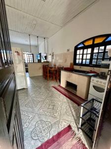 een keuken met een fornuis en een tafel. bij Casa aconchegante em Peruíbe in Peruíbe