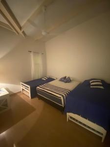 Zimmer mit 2 Betten und einem Tisch in der Unterkunft La Escondida Samber in San Bernardino