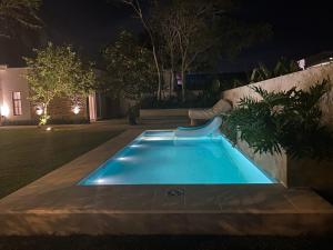 a swimming pool in a yard at night at La Escondida Samber in San Bernardino