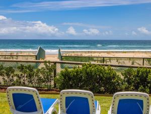 2 sillas sentadas frente a la playa en Breakers North Absolute Beachfront Apartments, en Gold Coast