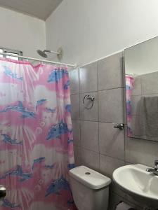 a bathroom with a shower curtain with a toilet and a sink at ARMANI in Puerto Colombia