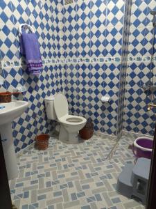 La salle de bains bleue et blanche est pourvue de toilettes et d'un lavabo. dans l'établissement راحة المسافر، Rahat al moussafir, à Azilal