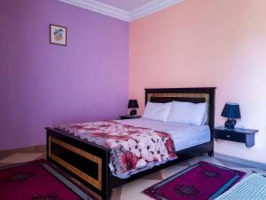 a bedroom with a bed with purple walls at راحة المسافر، Rahat al moussafir in Azilal