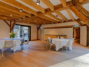 a room with two tables and chairs and wooden ceilings at De Jager in Ulvenhout