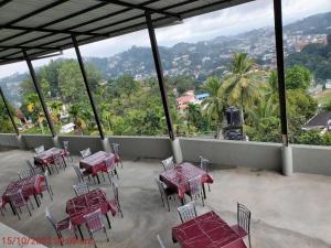 un patio con mesas y sillas y vistas a la montaña en CITY VIEW KANDY - MPM APARTMENT 4A en Kandy