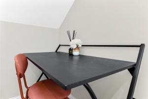 a black table with a vase of flowers on it at City Getaway- Newly Renovated Flat for Groups in Greenford