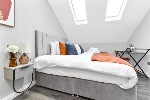 a bedroom with a bed with orange and blue pillows at City Getaway- Newly Renovated Flat for Groups in Greenford