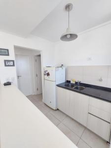 Messidor Mar del Plata Luminoso departamento 2 ambientes con cochera في مار ديل بلاتا: مطبخ أبيض مع ثلاجة ومغسلة