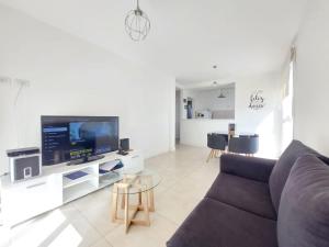 Messidor Mar del Plata Luminoso departamento 2 ambientes con cochera في مار ديل بلاتا: غرفة معيشة مع أريكة وتلفزيون بشاشة مسطحة