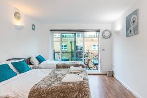 a bedroom with two beds and a balcony at 2&3 Bedrooms near EXCEL London - Modern Spacious Apartment For Larger Groups in London